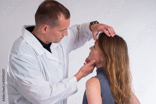 The doctor examines the pat...