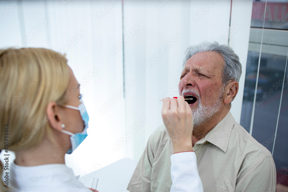 Doctor taking PCR test of an elderly patient during COVID-19 pandemic. Doctor taking PCR test of an elderly patient during COVID-19 pandemic.