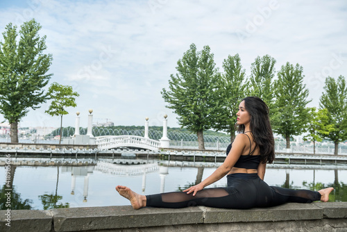 Girl in sportswear go in for sports and healthy lifestyle doing twine by lake © RomanR