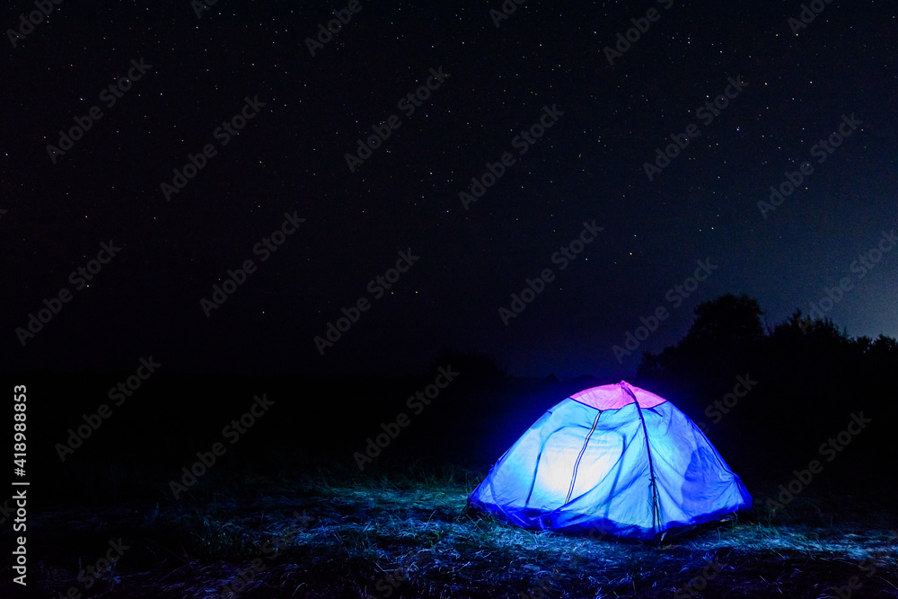 Tourist tent at night. Night sky with the many stars