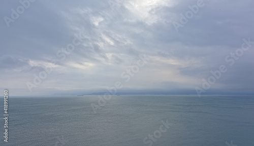 Semi abstract nature background in layers with different tints of blue of a cloudy sky above the calm north sea 