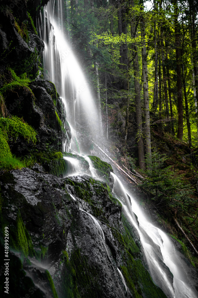 Fototapeta premium A beautiful waterfall in the forest during springtime.
