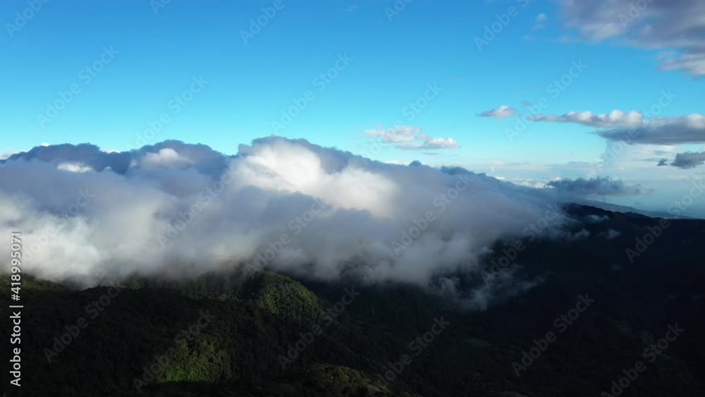 Fast moving clouds over cloud forest Monteverde mountains windy day aerial drone shot 