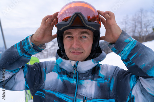 A man puts on a snowboard helmet