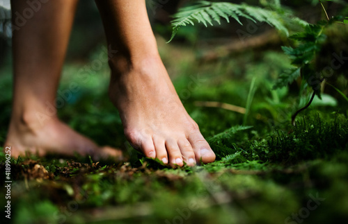 Bare feet of woman standing barefoot outdoors in nature, grounding concept. photo
