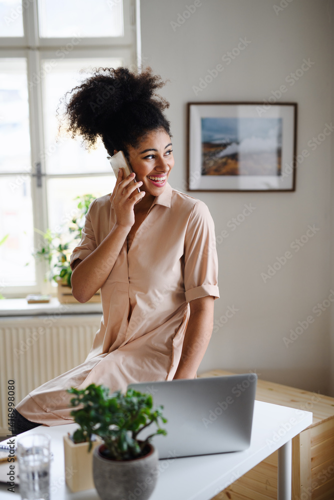 Young woman with laptop and smartphone indoors at home, home office concept. Young woman with laptop and smartphone indoors at home, home office concept.
