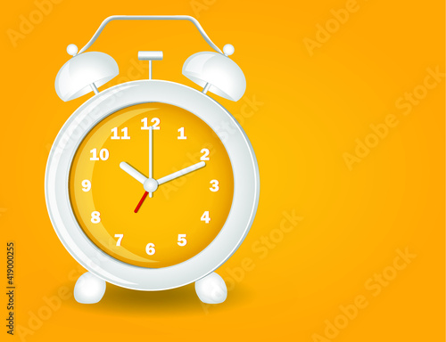 White and yellow analog classic alarm clock on yellow