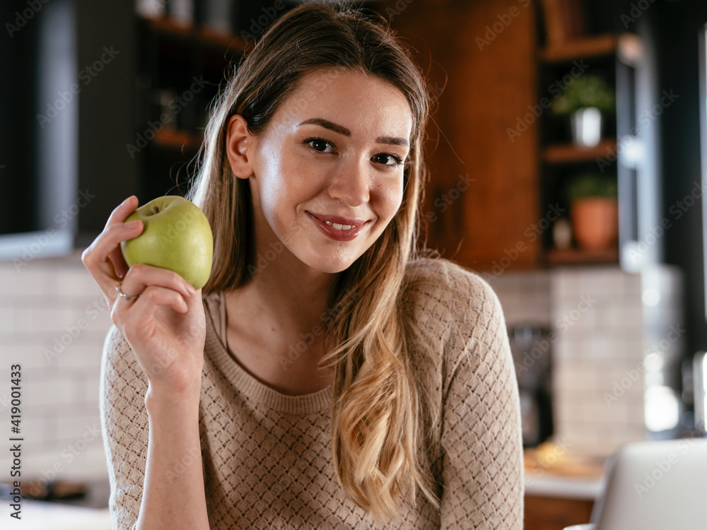 Portrait of a happy pretty girl holding an apple. Young woman eating fruit. Portrait of a happy pretty girl holding an apple. Young woman eating fruit.