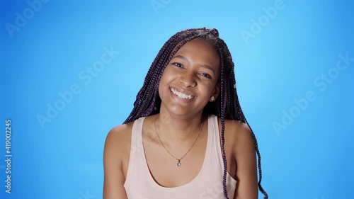 Portrait of a black African American woman looking smiling at the camera on a blue background. Chroma key background. photo