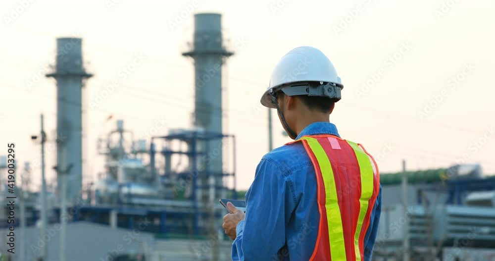 asian engineering working inside oil and gas refinery plant ,checking quality using digital tablet on industrial factory background asian engineering working inside oil and gas refinery plant ,checking quality using digital tablet on industrial factory background