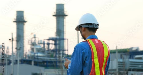 asian engineering working inside oil and gas refinery plant ,checking quality using digital tablet on industrial factory background	