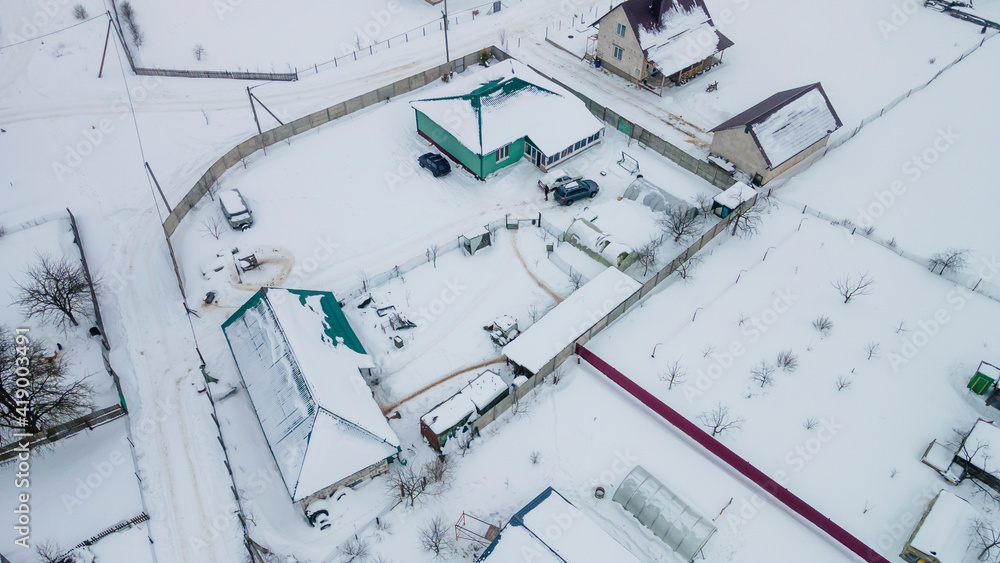 Aerial view over private houses in wintertime of snow covered traditional housing suburbs. Countryside concept. Aerial view over private houses in wintertime of snow covered traditional housing suburbs. Countryside concept.
