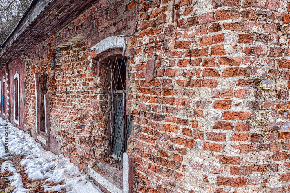 Crumbling brick wall of an old abandoned house Crumbling brick wall of an old abandoned house