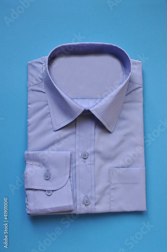 new fabric packed men's blue shirt on a blue background. Shirt packed for sale. Isolated shirt. Concept wear for bussiness