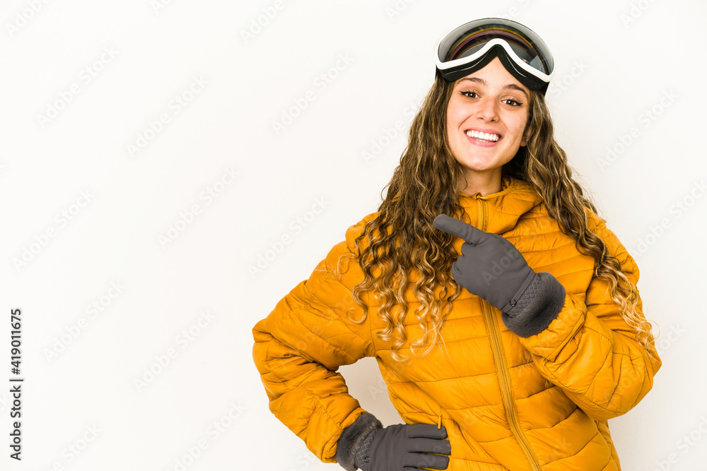 Young caucasian snowboarder woman isolated smiling and pointing aside, showing something at blank space. Young caucasian snowboarder woman isolated smiling and pointing aside, showing something at blank space.