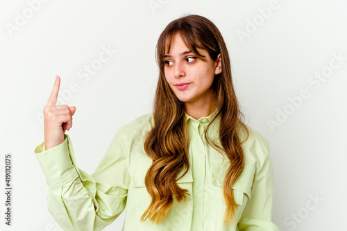 Young caucasian cute woman isolated on white background pointing with finger at you as if inviting come closer.