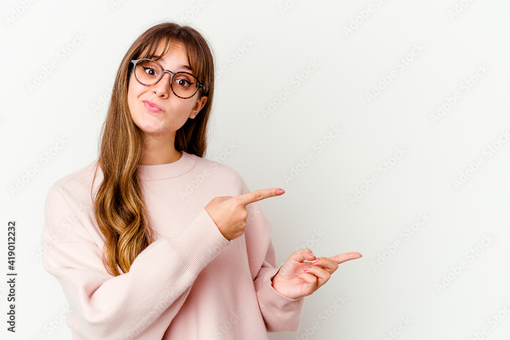 Young caucasian cute woman isolated on white background shocked pointing with index fingers to a copy space. Young caucasian cute woman isolated on white background shocked pointing with index fingers to a copy space.
