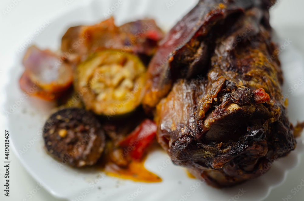 Bacon joint with bone served with grilled vegetables, red and yellow peppers, zucchini and red onion Bacon joint with bone served with grilled vegetables, red and yellow peppers, zucchini and red onion
