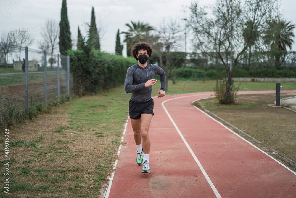 Chico joven con pelo rizado y atletico haciendo deporte Chico joven con pelo rizado y atletico haciendo deporte