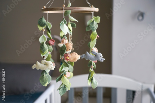 Diy craft baby crib mobile. Toys hang over the crib