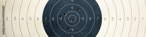 Target with numbers for shooting at a shooting range. A round target with a marked bull's-eye for shooting practice on the shooting range. Target with bullet holes