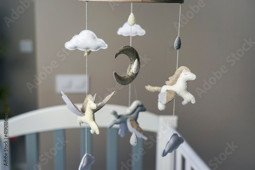 Diy craft baby crib mobile. Toys hang over the crib