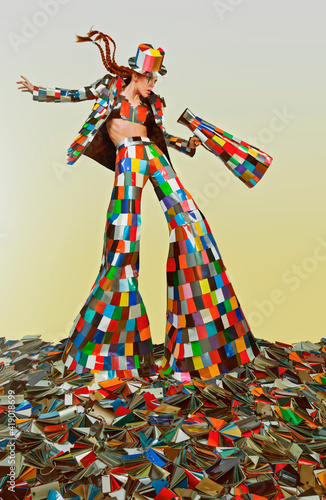 Female circus master dressed in a colorful suit and holding a megaphone, standing in the middle of a bunch of color samples photo