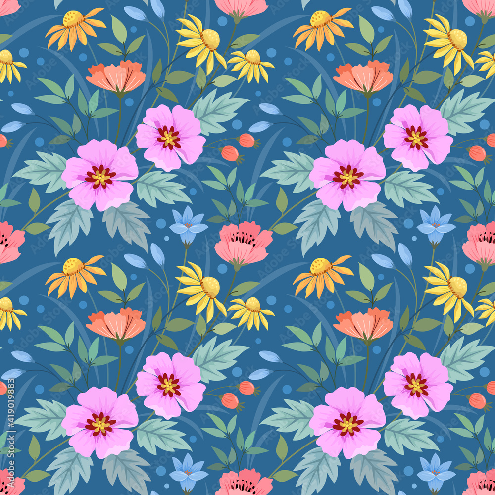 Colorful flowers and green leaves on a blue color seamless pattern for fabric textile background and backdrop.