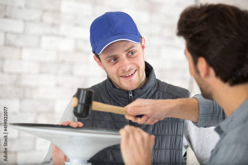 handyman using mallet to locate rubber seal into groove handyman using mallet to locate rubber seal into groove