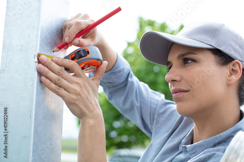 a woman measures the wall with a ruler close-up photo