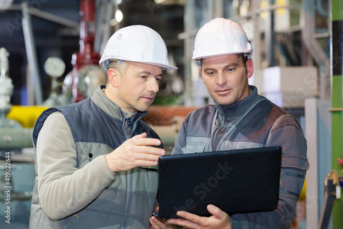 workers in the factory using laptop