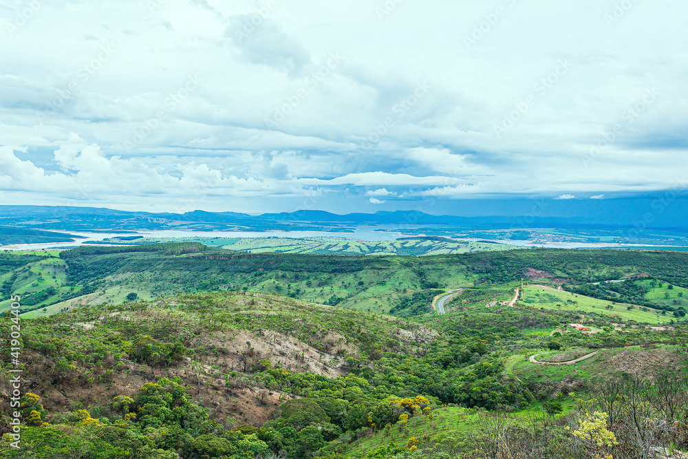 Wide panoramic view of nature beauties of Minas Gerais state. Vast green area with 
a mountainous terrain and the Lake of Furnas on background. Capitólio MG, Brazil. Mineiro eco tourism landscape.