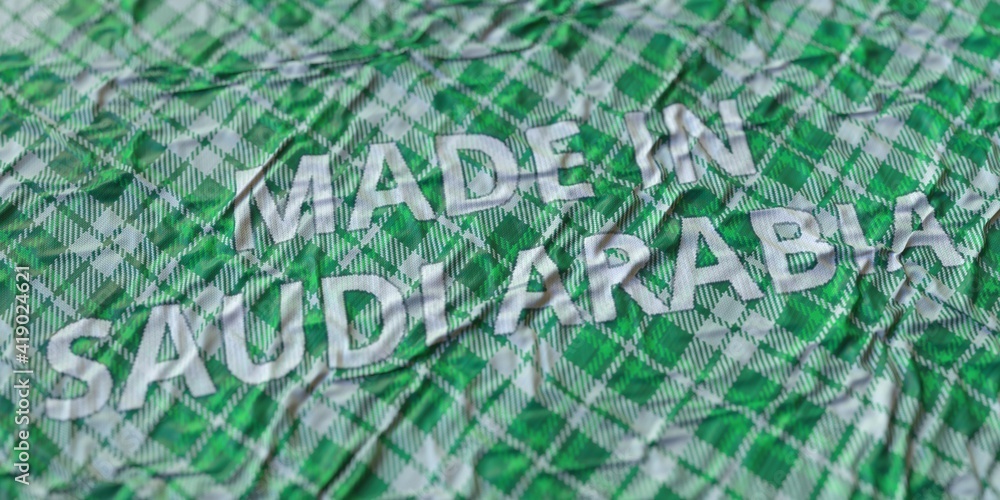 Fototapeta premium MADE IN SAUDI ARABIA words printed on a cloth, national textile production conceptual 3d rendering