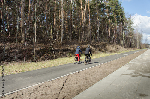 Para rowerzystów jadących po asfaltowej nawierzchni. Wiosenna aktywność. 