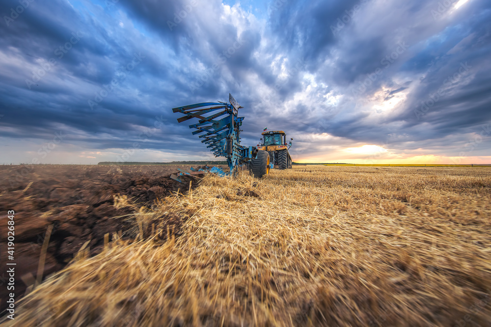 Fototapeta premium Tractor plowing the fields