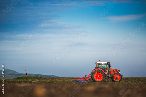 Fototapeta Naklejka Na Ścianę i Meble -  Farmer in tractor preparing land with seedbed cultivator
