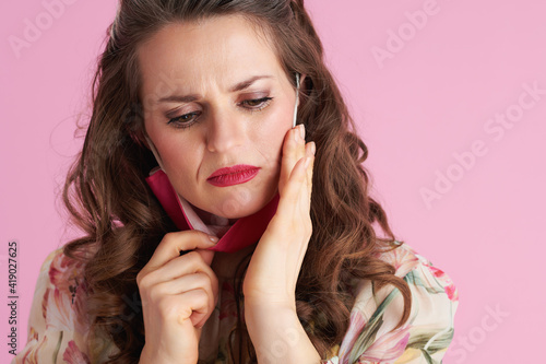 stylish woman concerned about skin condition on pink