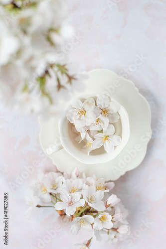 Tiny cute porcelain coffee cup filled with spring blossom flowers