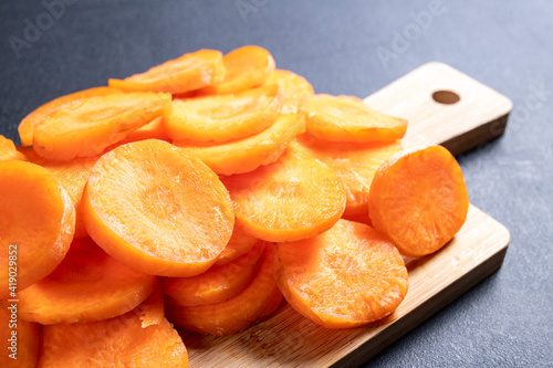 Tasty carrot slices arranged on a wooden board. Vegetables prepared for serving in home cooking.