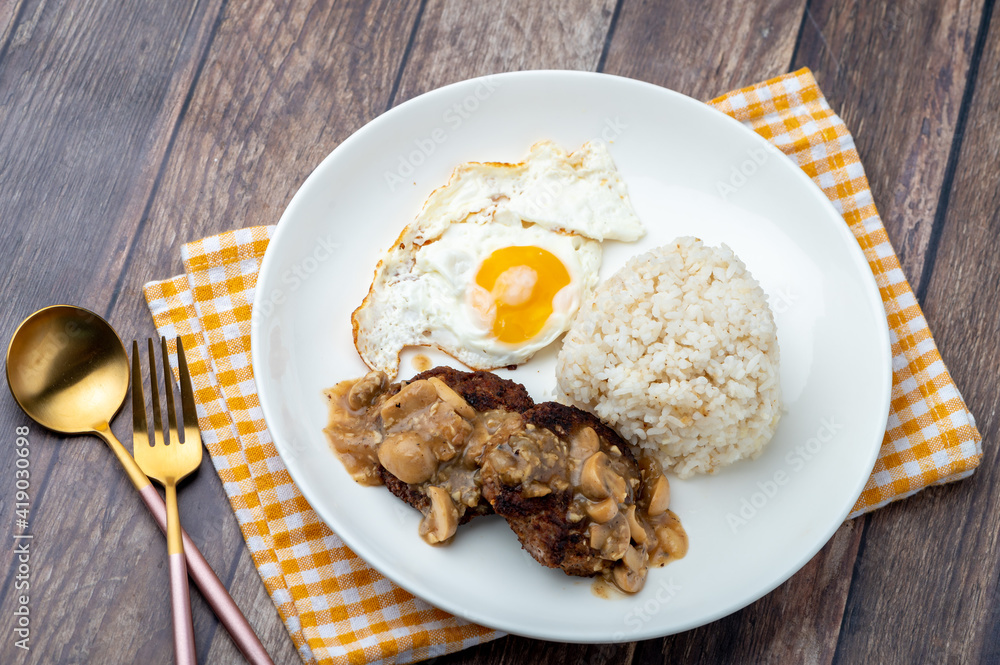 Mushroom Burger Steak Silog (zoom out)-is a famous Filipino meal that consists of burger steak covered in mushroom gravy sauce, egg and fried rice Mushroom Burger Steak Silog (zoom out)-is a famous Filipino meal that consists of burger steak covered in mushroom gravy sauce, egg and fried rice