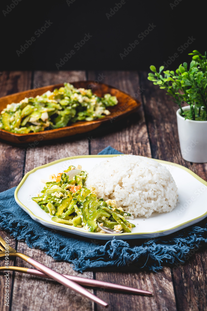 Ginisang Ampalaya (Sauteed Bittergourd) with Egg and Tomato (Full table vertical)- is a famous and healthy Filipino dish usually eaten with steamed rice. Ginisang Ampalaya (Sauteed Bittergourd) with Egg and Tomato (Full table vertical)- is a famous and healthy Filipino dish usually eaten with steamed rice.