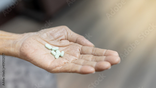 The senior man hands putting pills in his hand. The Old man taking care himself for health. Health and Medical concept.