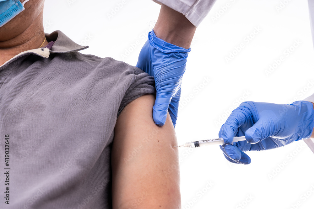 Close-up on Asian middle age man receiving Covid-19 vaccine injection onto the arm Close-up on Asian middle age man receiving Covid-19 vaccine injection onto the arm