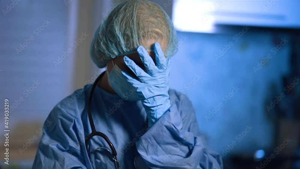 Face palm of female doctor in surgical mask during home visit Face palm of female doctor in surgical mask during home visit