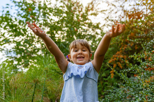 Happy girl throwing fruits of a plant into the air