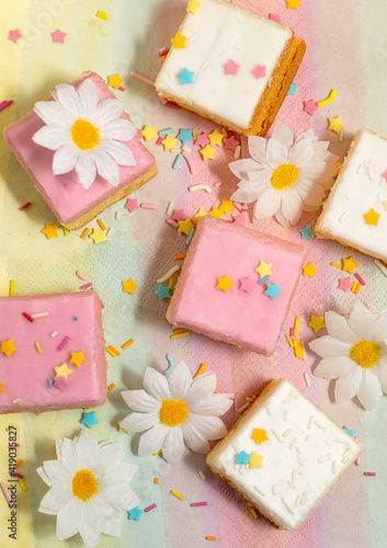 Pink and white iced cakes with sprinkles