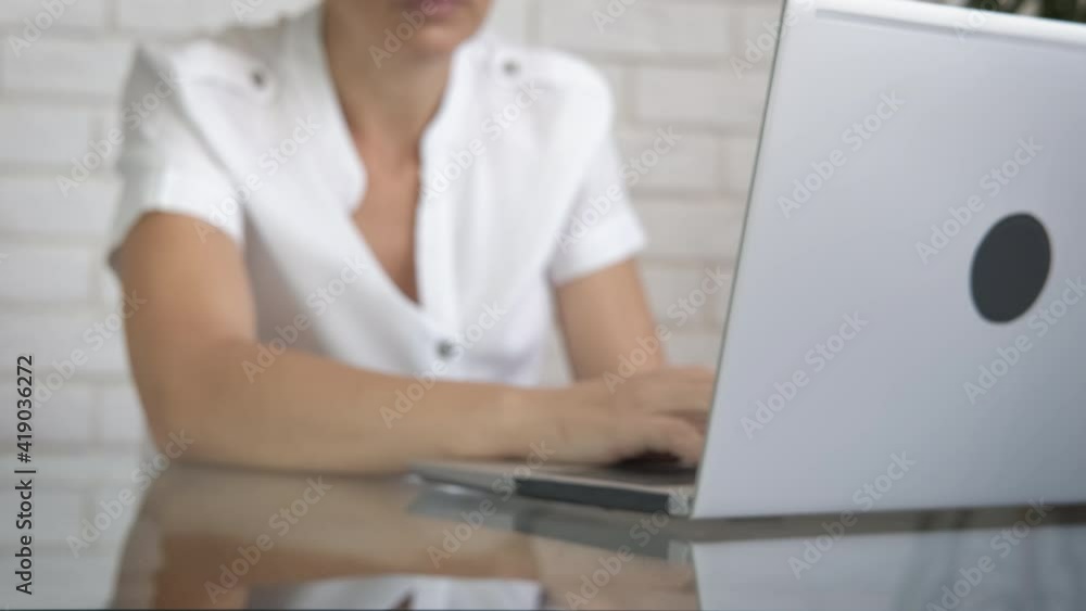 Hard migraine in the office. A woman with head pain puts it on the table on her workplace.