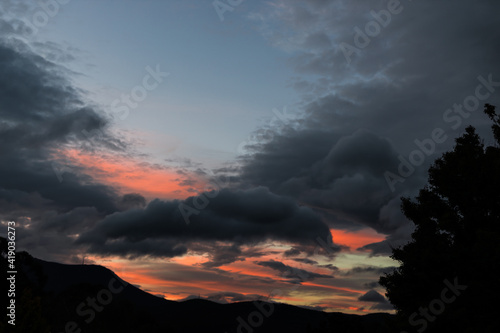 sunset over idyllic landcsape with mountains and thick vegetation
