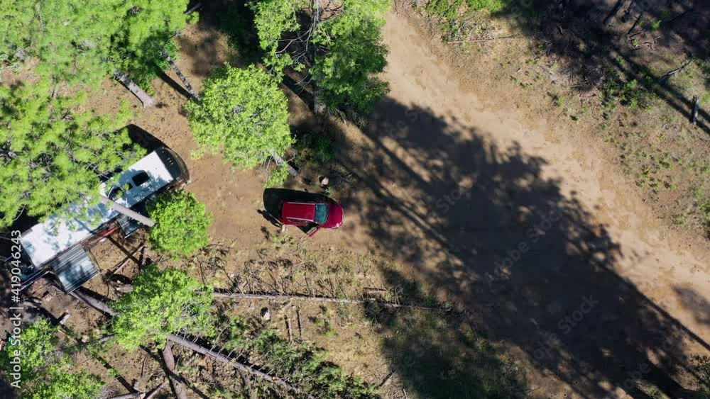 Aerial top view of tourist with vehicles amidst trees in forest, drone descending over campsite at national park - Yosemite National Park, California Aerial top view of tourist with vehicles amidst trees in forest, drone descending over campsite at national park - Yosemite National Park, California