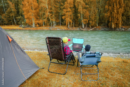 boys watching movies in laptop outdoors